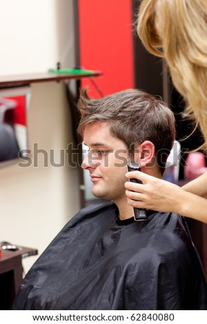 stock photo Young caucasian man being shaved in a hairdressing salon
