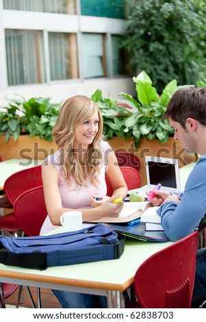 Two students working together in the library of their university