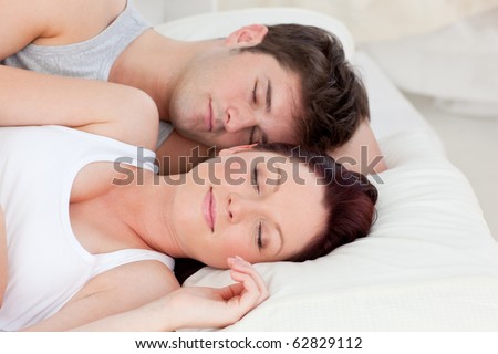 Enamored young couple sleeping in bed together in the bedroom