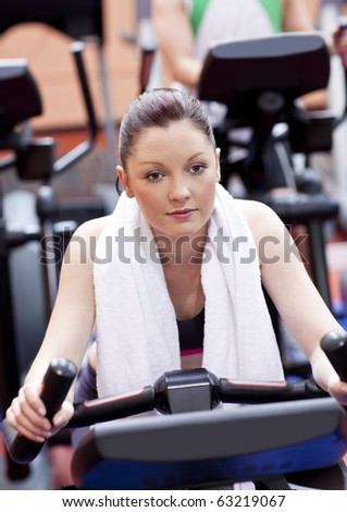 Serious athletic woman pedaling during a training in a sport centre