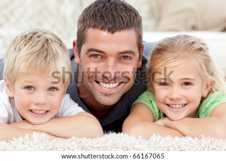 Portrait of a father and his children on the floor at home