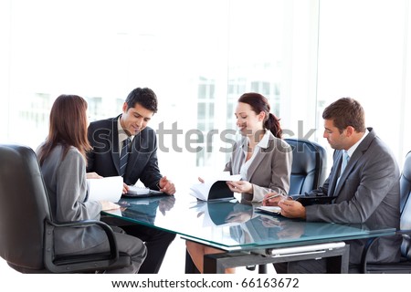 Four business people during a meeting sitting around a table