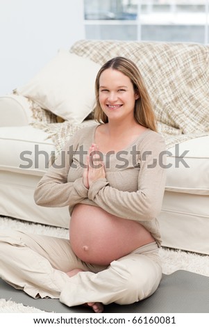 Joyful woman doing yoga posture on the floor of the living room at home