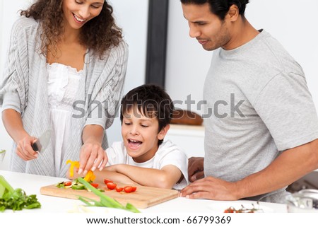 Happy family preparing a salad together in the kitchen at home