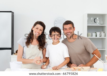 Portrait of a happy family preparing biscuits together in the kitchen