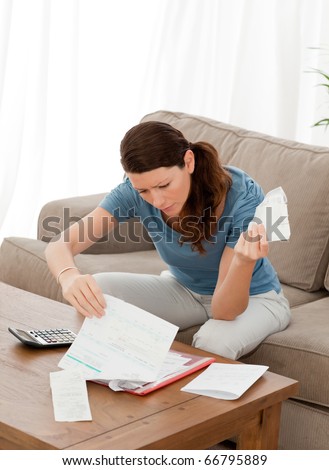 Pretty woman looking at her financial debts at home