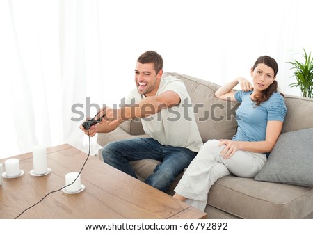 Desperate woman being bored while her boyfriend playing video game at home