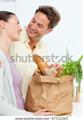 Lovely couple coming back from the market with vegetables in shopping bags
