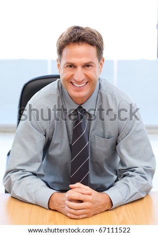 Happy manager sitting at a table in an office