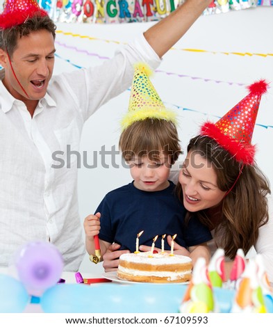 Cute boy blowing the candles on his birthday cake