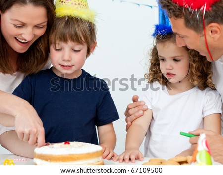 stock photo Mom and son cutting a birthday cake together in the kitchen 
