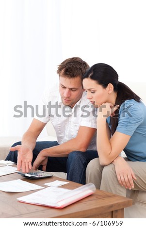 Desperate couple doing their account sitting on the sofa of the living room
