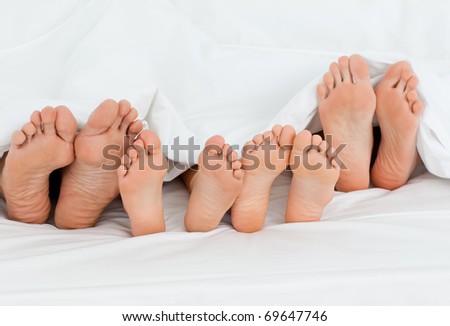 Family on the bed at home with their feet showing Family on the bed at home with their feet showing