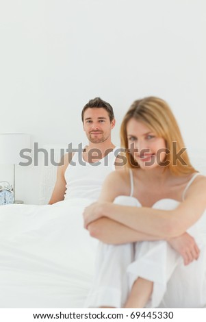 Superb woman looking at the camera with her husband at home