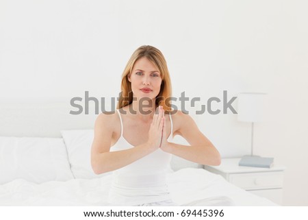Woman practicing yoga on her bed at home