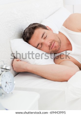 A peaceful man in his bed before waking up in his bedroom