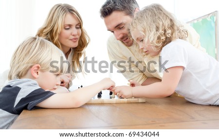 Family playing chess on a table at home