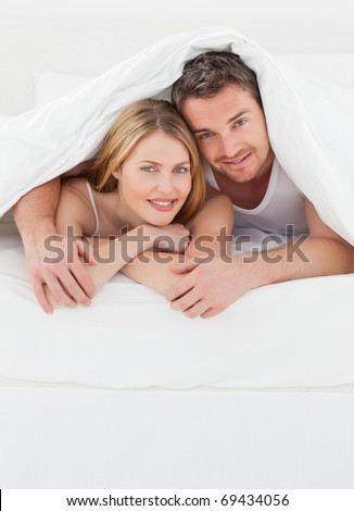 Lovely pair hugging  in their bed in their bedroom