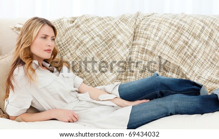 Wonderful woman lying down on her sofa at home