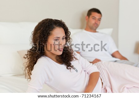 Thoughtful woman with her husband on the bed