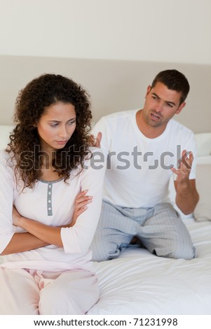 Young couple having a dispute on the bed at home