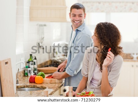 Beautiful woman looking at her husband who is cooking at home