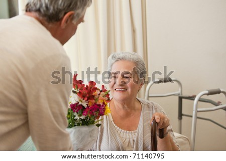 Retired man offering flowers to his wife