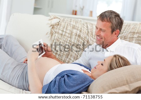 Couple looking at X-ray on their couch at home