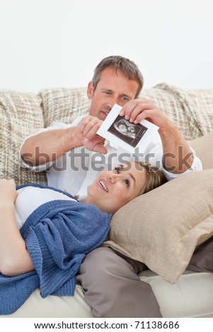 Couple looking at an X-ray on their couch at home