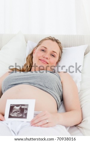 Delighted pregnant woman with her X-ray at home