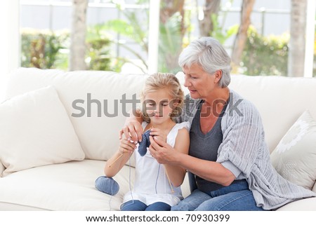 Senior knitting with her granddaughter at home