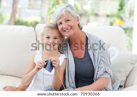 Senior knitting with her granddaughter at home