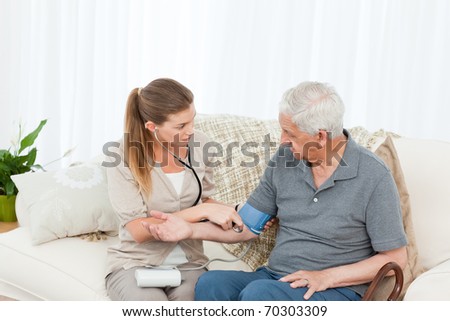 Lovely nurse helping her patient to do exercises at home