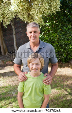Father and his son looking at the camera in the garden