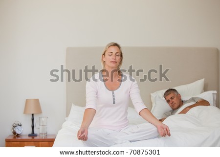 Lovely woman practicing yoga on her bed