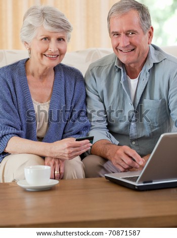 Retired couple looking at their laptop at home