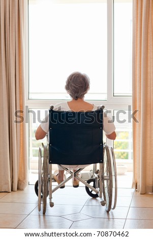 Mature woman in her wheelchair with her back to the camera