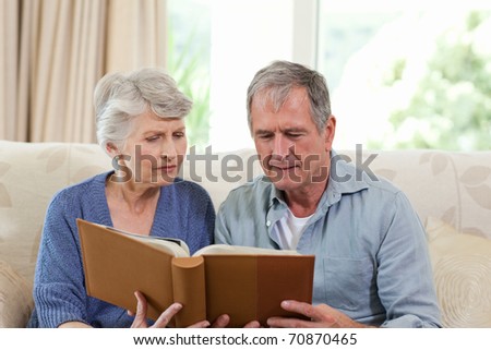 Seniors looking at their photo album at home