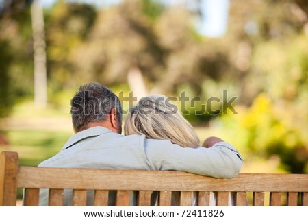 Elderly couple sitting on the bench with their back to the camera