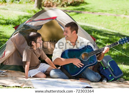 Father playing guitar with his son
