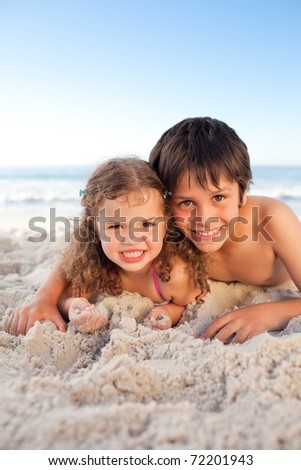 Little Boy And His Sister Lying Down On The Beach Stock 