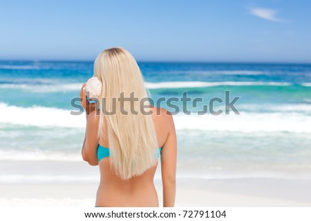 Lovely woman listening to her shell