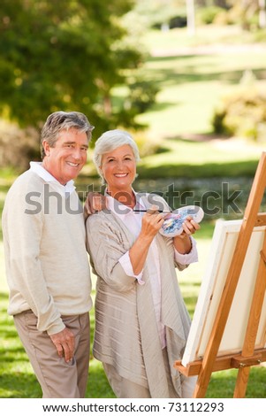Senior couple painting in the park
