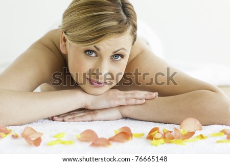 Pretty blond-haired woman happy while lying down in a spa centre