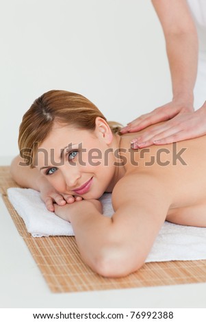 Young blond-haired woman getting a massage in a spa center