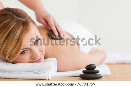 Therapist making a massage to a beautiful blond-haired woman in a spa center