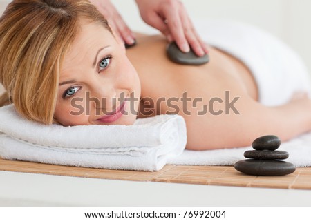 Therapist making a massage to a pretty blond-haired woman in a spa center