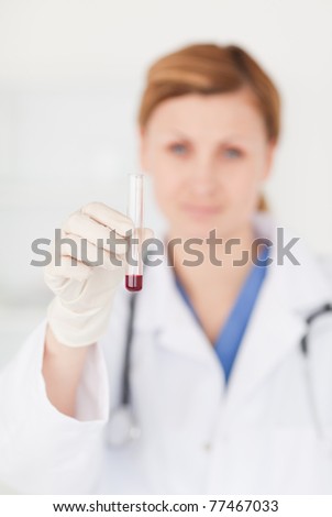 Female scientist looking at the camera while holding a test tube in a lab