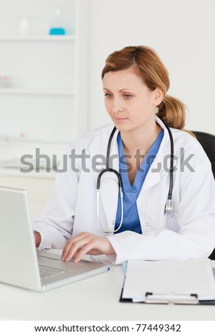 Concentrated doctor working on her laptop in her office