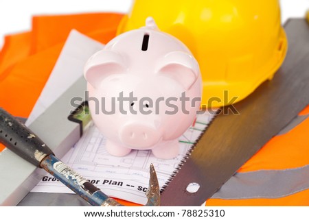 Tools and miniature house on an orange jacket against a white background